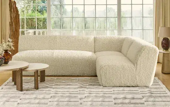 Cozy white Sohnne wool sectional sofa in a sunlit living room with coffee tables